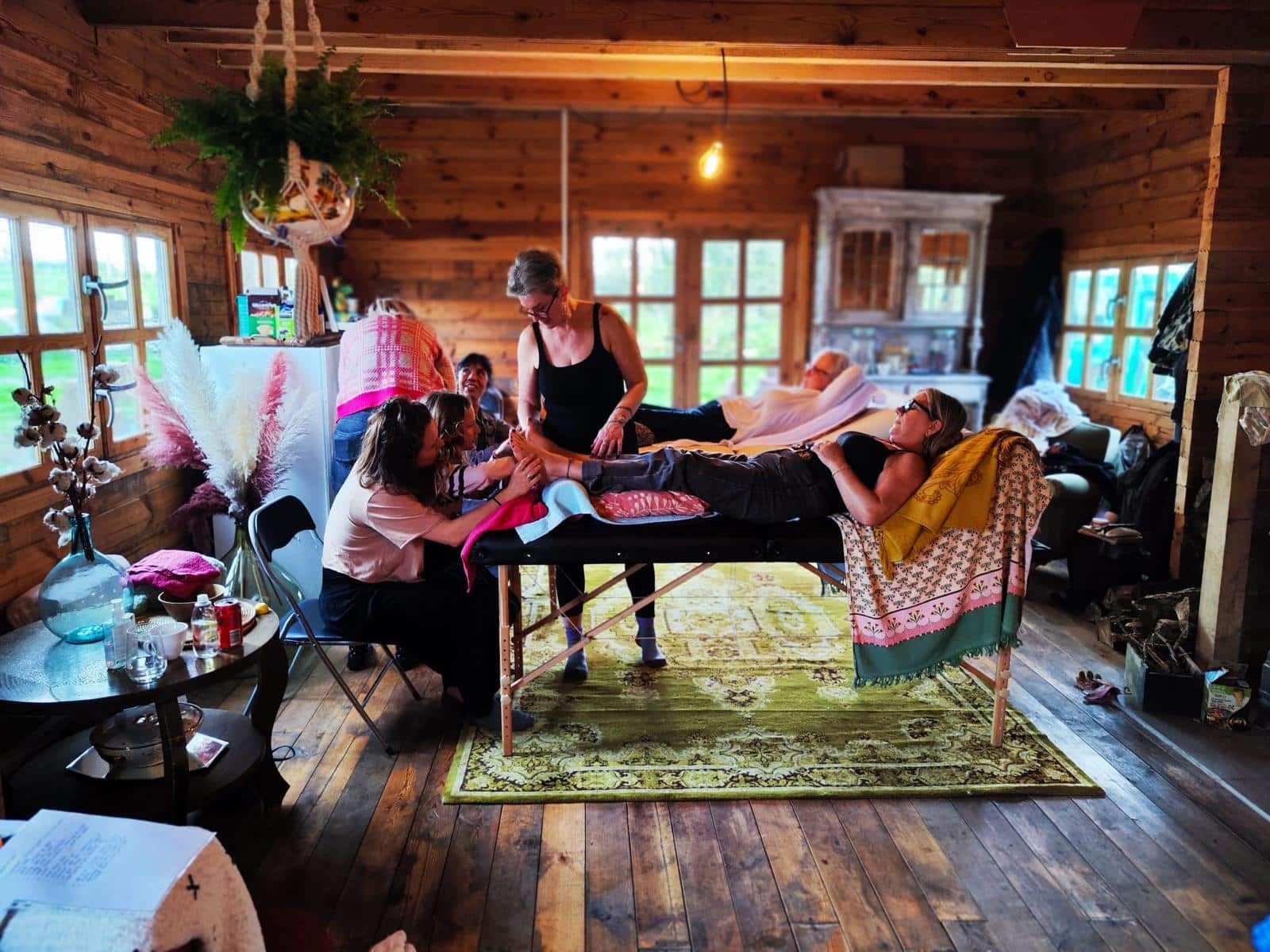 Chalet en bois avec table de massage posées pour formation en réflexologie plantaire